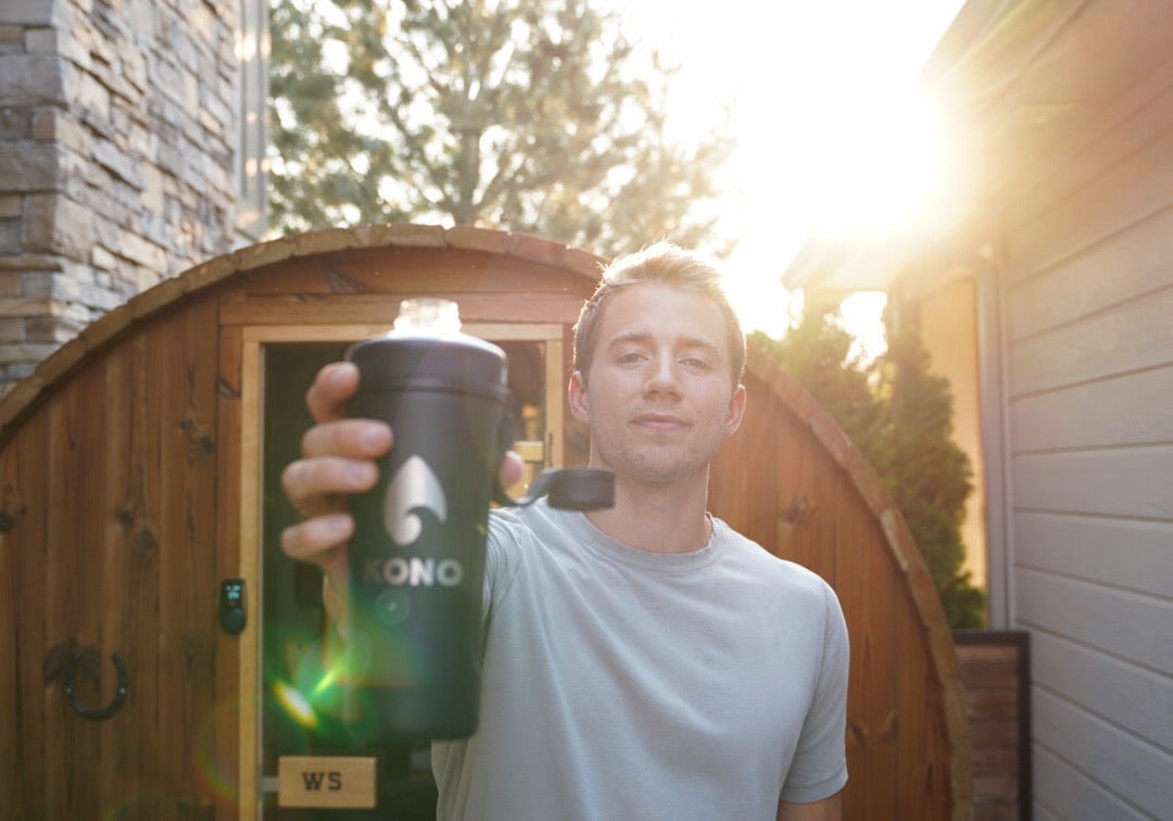 recovery scene: KONO shaker raised outside a sauna, casual t-shirt and sunburst in background