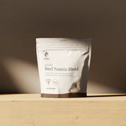 KONO Beef Protein Blend - raw chocolate pouch on a wooden shelf in soft natural light.