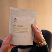 Close-up of KONO Magnesium supplement pouch, Lemon & Chamomile flavor, held in both hands.