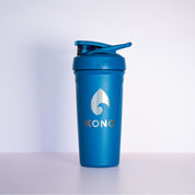 Blue shaker: Blue KONO BlenderBottle shaker cup with flip cap and metal logo, durable gym protein mixer photographed against a white background.