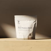  KONO Beef Protein Blend -Madagascar vanilla pouch on a wooden shelf in soft natural light.