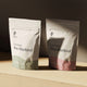 KONO Functional Pre-Workout drink mix—Lemons & Limes and Strawberries flavors, two stand-up pouches on a wooden shelf, minimalist product photo.