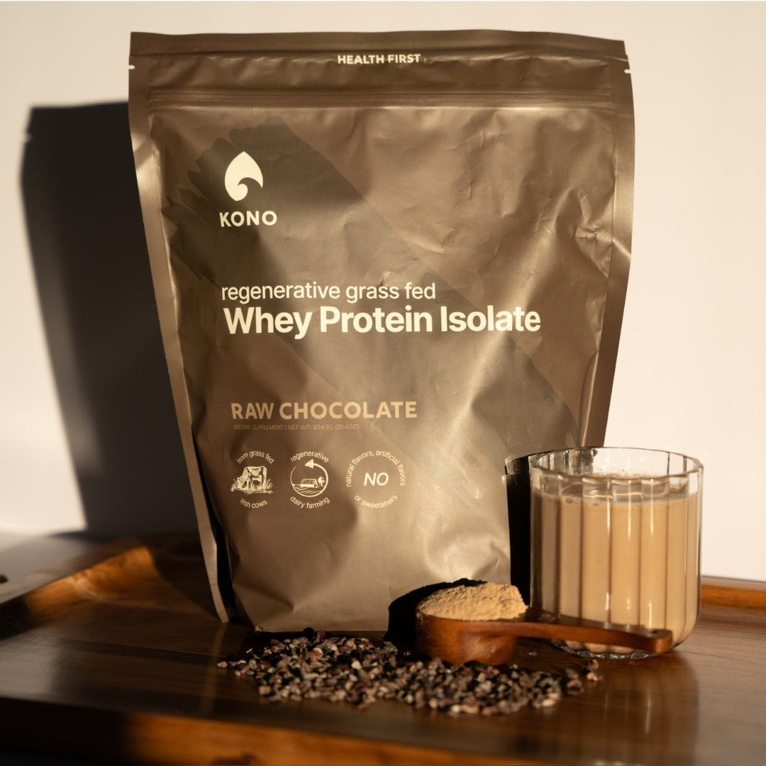 KONO regenerative grass-fed Whey Protein Isolate Raw Chocolate—product pouch with chocolate protein shake in glass and cocoa nibs.