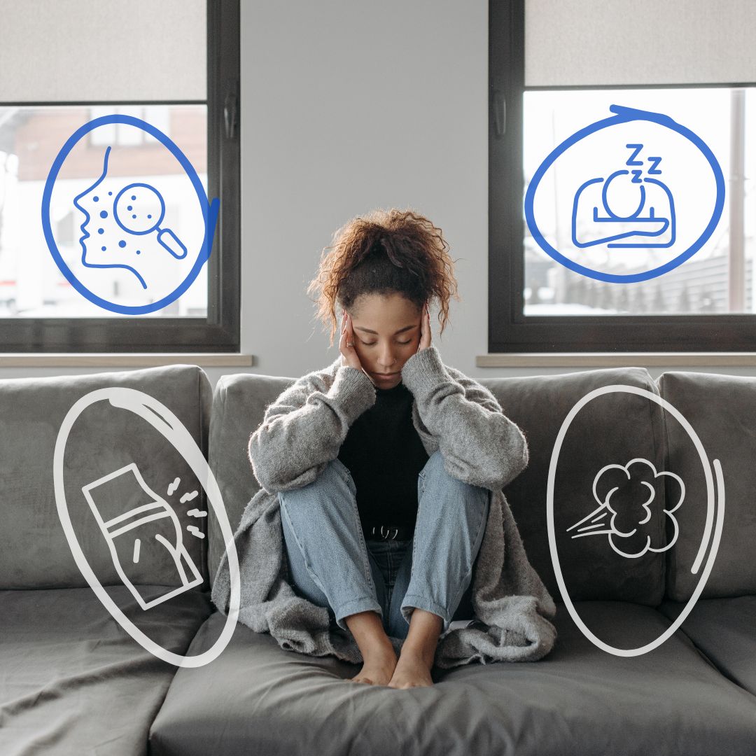 Woman sitting on a couch holding her head, surrounded by illustrated icons